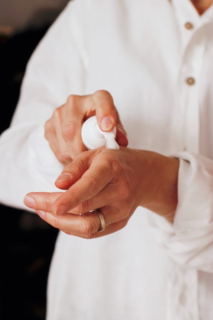 Pessoa aplicando espuma hidratante em sua mão.